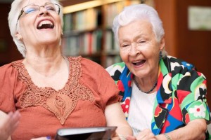 Senior-female-friends-laughing-while-using-digital-tablet